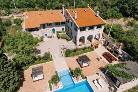 Gazebos with sun loungers stand in the courtyard of an ancient villa near the pool. Top view. High quality photo