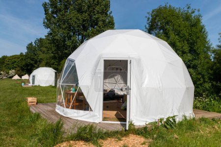 A close view of a glamping pod on a field on a farm. 