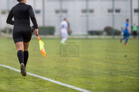 Foto de A female assistant referee runs by the touchline during a match - Imagen libre de derechos