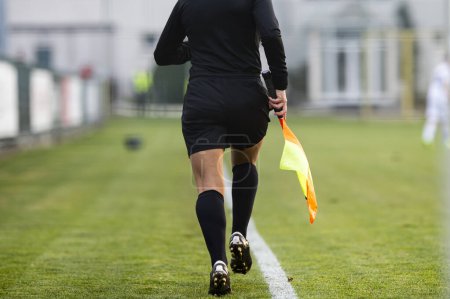 Foto de Una mujer árbitro asistente corre por la línea de contacto durante un partido - Imagen libre de derechos