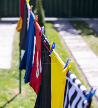 Colorful clothes hanging to dry on a laundry line. Football jerseys