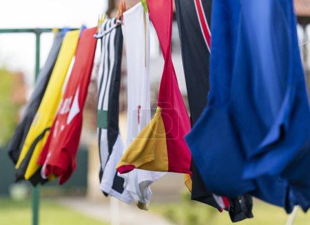 Colorful clothes hanging to dry on a laundry line. Football jerseys 