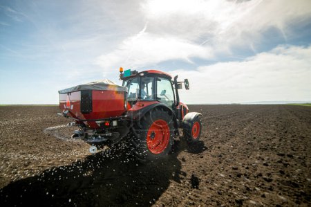 Tracteur épandant des engrais artificiels. Transports, agriculture.