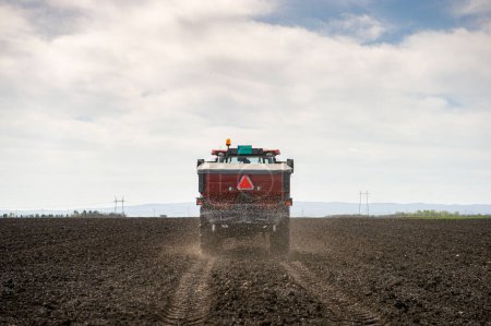 Tractor propagando fertilizantes artificiales. Transportes, agricultura.