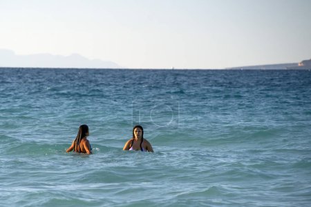 Photo for Two beautiful black hair mexican latina girls swimming in Cortez Sea on baja california beach - Royalty Free Image