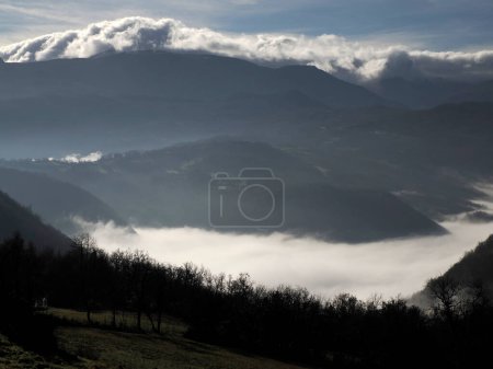Téléchargez les photos : Low clouds like fog in appennines valley around Bismantova stone a rock formation in the Tuscan-Emilian Apennines (Italy). - en image libre de droit