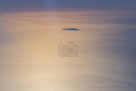La isla Ustica vista aérea desde el avión al atardecer dorado, mientras volaba sobre las Islas Eolias, Sicilia, Italia
