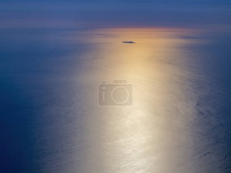The Ustica island aerial view from airplane at golden sunset, while flying over Aeolian Islands, Sicily, Italy