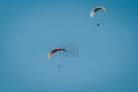 Photo for Paragliding soaring through the heights, you can see clouds and the blue sky - Royalty Free Image