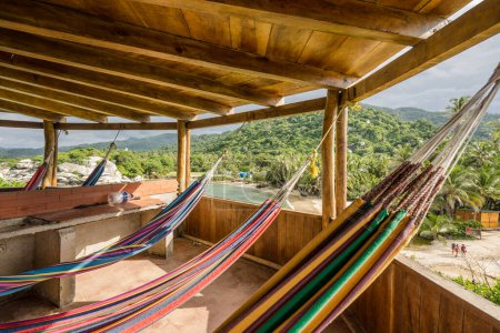 Téléchargez les photos : Hébergement en tour au Carbo San Juan dans le parc national de Tayrona. Plage caribéenne avec vue sur un hamac calme, relaxant et coloré en Amérique du Sud, Colombie. Découvrez la jungle et les palmiers - en image libre de droit