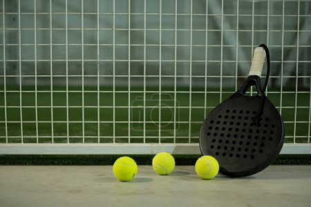 Photo for Paddle tennis racket and balls on court, night image - Royalty Free Image