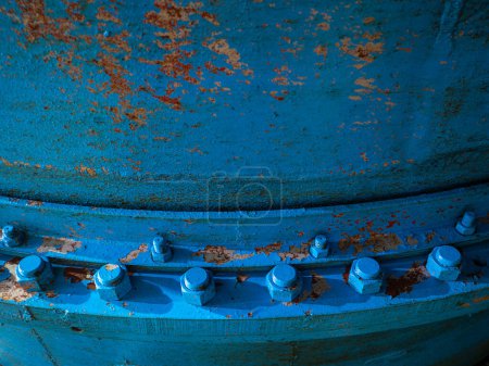 Foto de Pernos y tuercas en tubería de agua azul. Juntas de brida metálica de tuberías grandes en central hidroeléctrica. Enfoque de cerca y elija el tema - Imagen libre de derechos