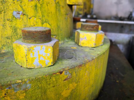 Photo for Bolts and nuts on yellow flange. Metal flange joint of hydraulic jack on hydroelectric power plant. Focus closely and choose the subject - Royalty Free Image