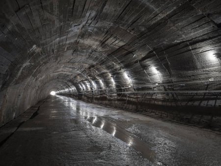 Foto de Oscuro espeluznante gran túnel con techo arqueado, en el viejo búnker subterráneo abandonado. Concepto de la luz al final de un túnel - Imagen libre de derechos
