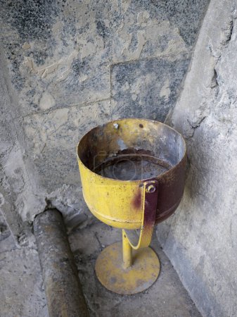 Foto de Viejo hierro oxidado amarillo, con pelado pintura basura urna se encuentra en esquina cerca de la pared de hormigón, fondo concepto - Imagen libre de derechos