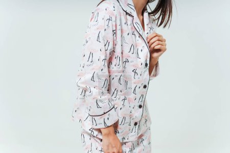 details of a nightgown with a flamingo pattern on a girl. photo session of a silk women's sleep set on a woman. patterned women's pajamas