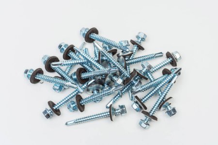 Photo for Roofing screws on a white background. photo of self-tapping screws for the catalog on a light background. set of bolts for working with metal tiles and iron - Royalty Free Image