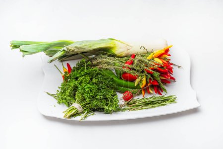 Téléchargez les photos : Herbes fraîches et épices sur une assiette blanche. préparation d'ingrédients frais pour la cuisine dans le restaurant - en image libre de droit