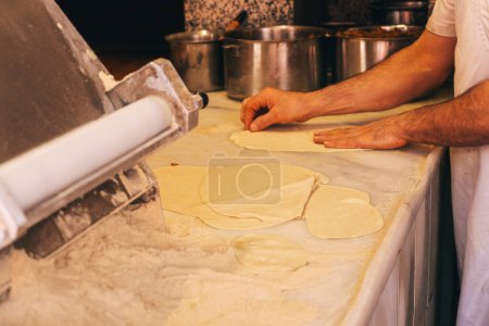 Téléchargez les photos : Cuisiner lahmajun turc dans un café en feu. Un cuisinier turc travaille dans une cuisinière chaude. Un homme turc cuisine une pizza turque à Istanbul - en image libre de droit