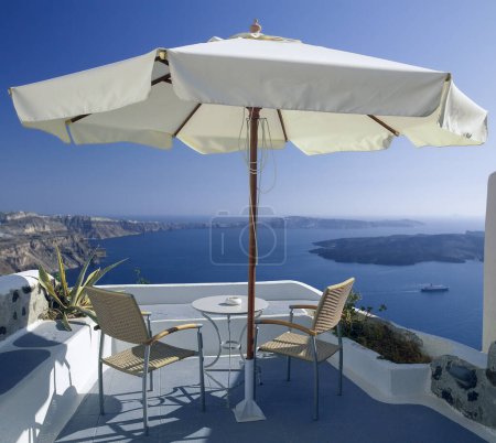 Photo for Patio with a view over the volcanic caldera in the town of Oia on the Greek volcanic island of Santorini (Thira) in the southern Aegean Sea. - Royalty Free Image