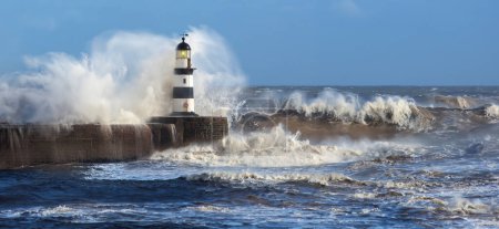 Photo for Waves crashing over Seaham Lighthouse on the northeast coast of England. - Royalty Free Image