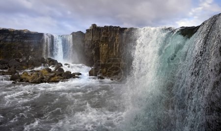 Téléchargez les photos : Chutes d'eau dans une partie de la vallée de la faille à Pingvellar causées par le mouvement tectonique des plaques nord-américaines et européennes qui déchirent les terres, élargissant l'Islande de 1,5 cm par an - en image libre de droit