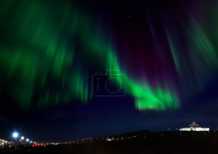Aurora Borealis above the Perlan Building in Reykjavik, Iceland. Auroras, (northern and southern lights), are natural light displays in the sky, particularly in the polar regions. They occur in the ionosphere. 