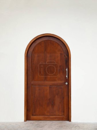 Foto de Puerta de madera arqueada clásica en la pared blanca. - Imagen libre de derechos