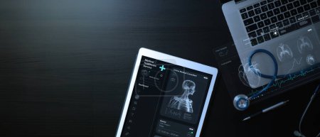 Foto de Vista superior del cardiólogo médico médico escritorio con tableta digital portátil estetoscopio sobre fondo escritorio de madera oscura. - Imagen libre de derechos