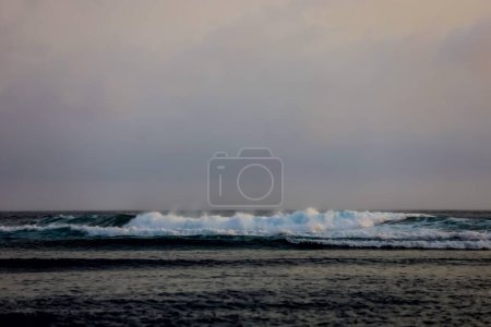 Foto de La línea del horizonte en la playa de la bahía de Asmara es ligeramente azul cielo. Las olas continuaron rugiendo con vientos bastante fuertes. Teluk Asmara Beach en Malang Indonesia, una playa que todavía no es visitada por muchos turistas. - Imagen libre de derechos