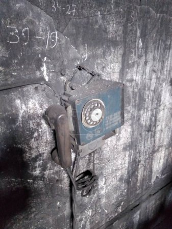 Téléchargez les photos : Vieux téléphone sur le mur d'un bâtiment industriel. Intérieur industriel. Vintage. - en image libre de droit