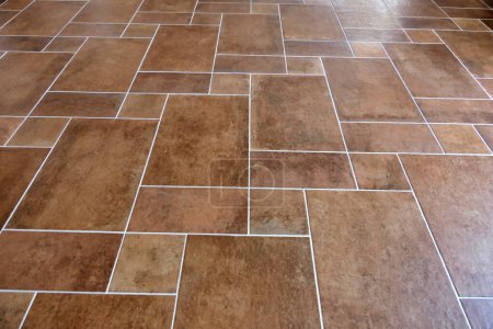 Newly laid Italian terracotta brown floor tiles finished with grey grouting