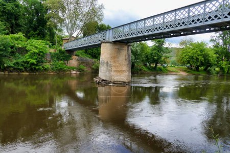 Large tree trunks swept down the Vezere River following heavy rains and flooding. Finally coming to rest against the stone supports of the iron bridge across the Vezere river in St Leon sur Vezere in the Dordogne, France