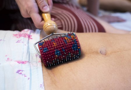Téléchargez les photos : Postpartum doula montre comment masser une cicatrice césarienne avec un applicateur Lyapko. Procédures de récupération après l'accouchement. - en image libre de droit