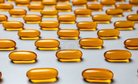Photo for Yellow capsules omega-3 on a gray background. Pattern. Pantone colors of 2021. High quality photo - Royalty Free Image