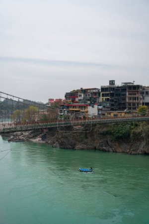 Téléchargez les photos : Rishikesh, Inde, mars 2024. Vue du remblai de la rivière Ganga et du pont Lakshman Jhula à Rishikesh. Photo de haute qualité - en image libre de droit