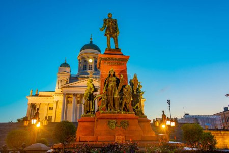 Sunrise view of the cathedral and statue of Alexander II in Senaatintori - Senate square in Helsinki, Finland .