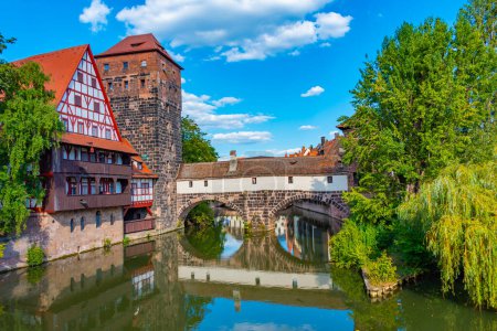 Téléchargez les photos : Vieille ville historique avec vue sur le bâtiment Weinstadel, le château d'eau, le pont Henkerbrucke et la tour Henkerturm à Nurnberg, Allemagne.. - en image libre de droit