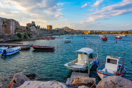 Téléchargez les photos : Coucher de soleil sur les bateaux amarrés le long du château de Methoni en Grèce. - en image libre de droit