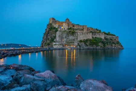 Blick auf das Castello Aragonese vor der Küste der italienischen Insel Ischia bei Sonnenuntergang.