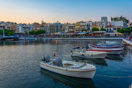 Téléchargez les photos : Agios Nikolaos, Grèce, 19 août 2022 : Coucher de soleil sur le lac Voulismeni et la ville grecque Agios Nikolaos sur l'île de Crète. - en image libre de droit