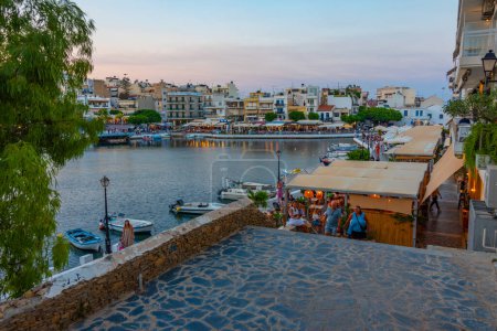 Téléchargez les photos : Agios Nikolaos, Grèce, 19 août 2022 : Coucher de soleil sur le lac Voulismeni et la ville grecque Agios Nikolaos sur l'île de Crète. - en image libre de droit