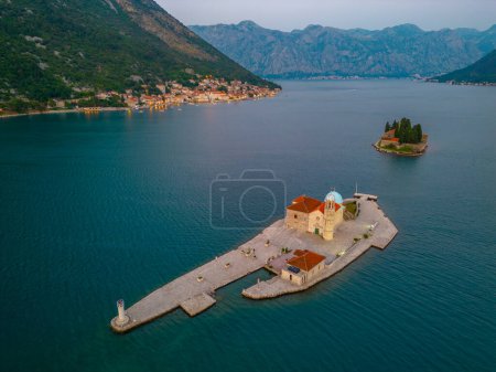 Vista aérea al atardecer de la Iglesia de Nuestra Señora de Skrpjela y el Monasterio Católico de San Jorge cerca de Perast en Montenegro