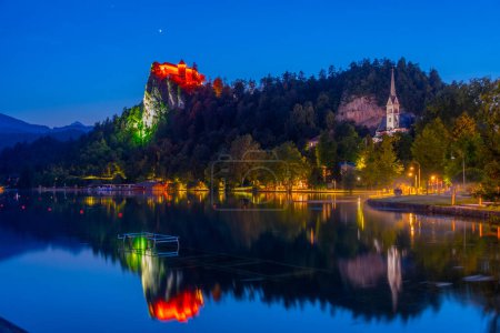Vista al atardecer de la iglesia de San Martín y el castillo de Bled en Eslovenia