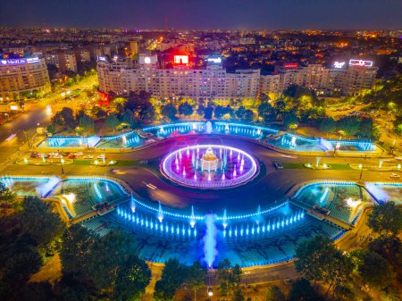 Téléchargez les photos : Bucarest, Roumanie, 21 août 2023 : Coucher de soleil vue panoramique d'une fontaine sur la place Unirii à Bucarest, Roumanie - en image libre de droit