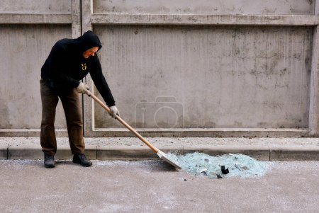 Foto de A man removes broken glass from an apartment building in Kyiv, which suffered from a kamikaze drone attack by the Russian Federation on the night of December 30, 2022. - Imagen libre de derechos