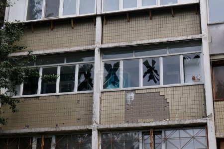 Foto de KYIV, UCRANIA - 13 DE JULIO: Un transeúnte observa un edificio residencial en el distrito de Shevchenkivskyi de la ciudad dañado por un avión no tripulado Shahed kamikaze caído el 13 de julio de 2023 en Kiev, Ucrania - Imagen libre de derechos
