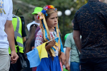 Téléchargez les photos : Une fille portant vyshyvanka et une couronne passent devant un véhicule blindé russe détruit exposé sur la rue Khreshchatyk le jour de l'indépendance de l'Ukraine, le 24 août 2023 à Kiev, en Ukraine. - en image libre de droit