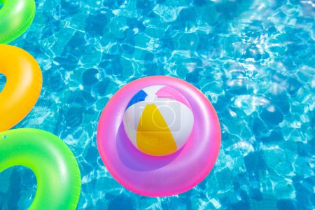 Foto de Piscina inflable con anillo de natación y anillos en un agua sobre fondo azul en el día de verano. - Imagen libre de derechos