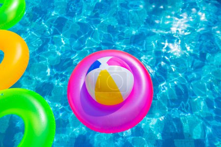 Photo for Inflatable pool with swimming ring and rings in a water on blue background in the summer day. - Royalty Free Image